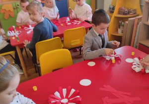 Dzieci wykonują kotylion biało- czerwony.